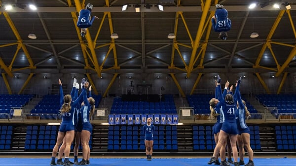 Acrobatics and tumbling team members throw two teammates in the air during a routine