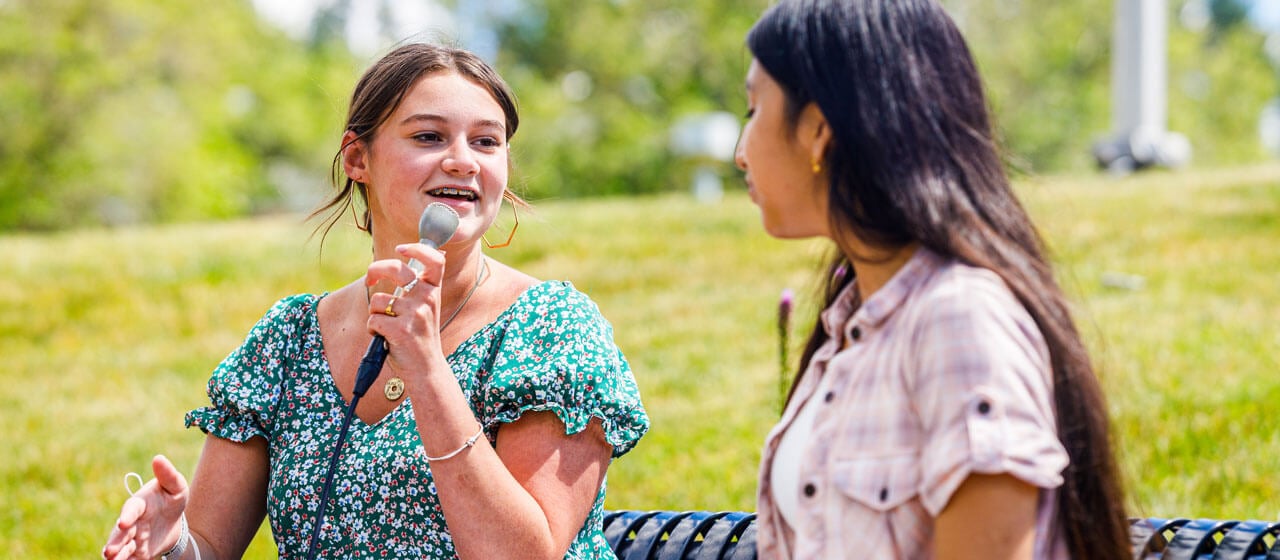 High school students conduct an interview outside during Ability Media camp