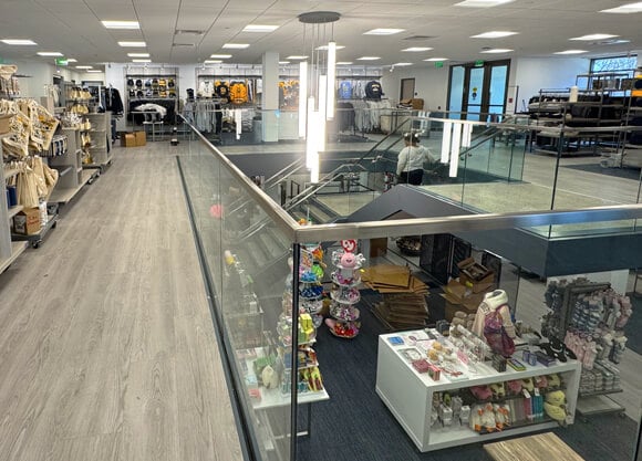 A person walks down the stairs in the center of the Quinnipiac bookstore with merchandise on display