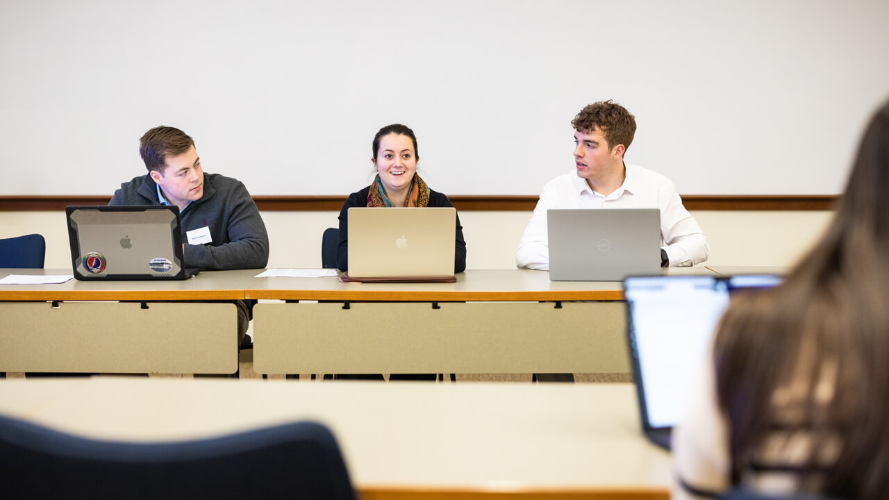 Three people sitting with laptops