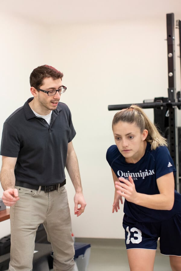 A male student observes a female soccer players as she runs inside