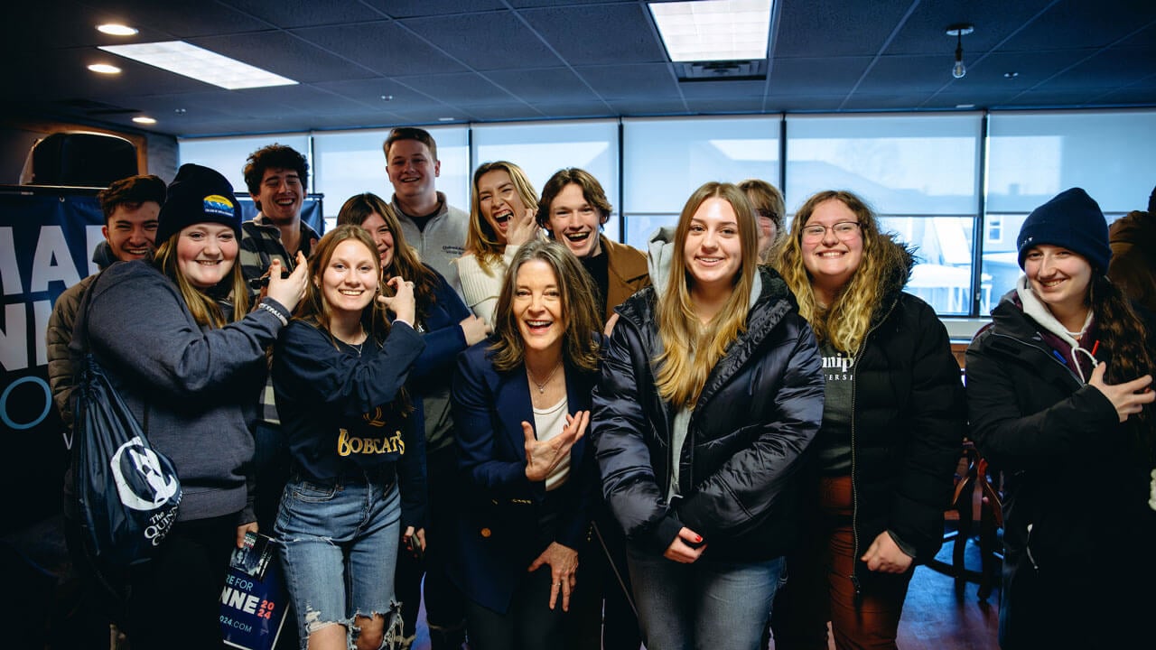 Quinnipiac students smiling and doing the Bobcat Roar