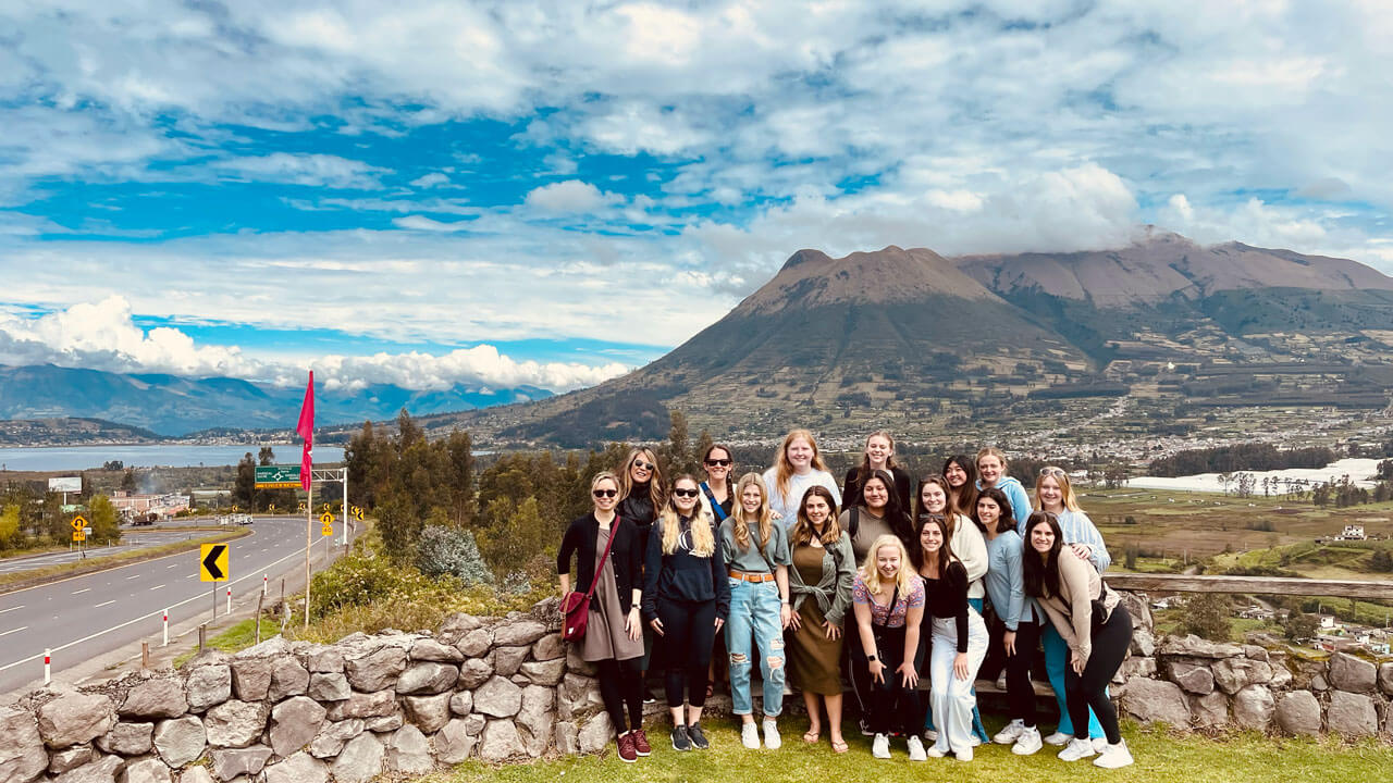 Students stand in front of Volcan Pichincha while studying in Ecuador
