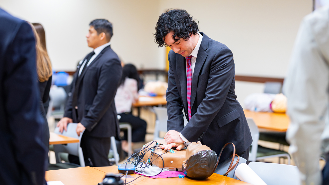 Student practices CPR on a dummy.