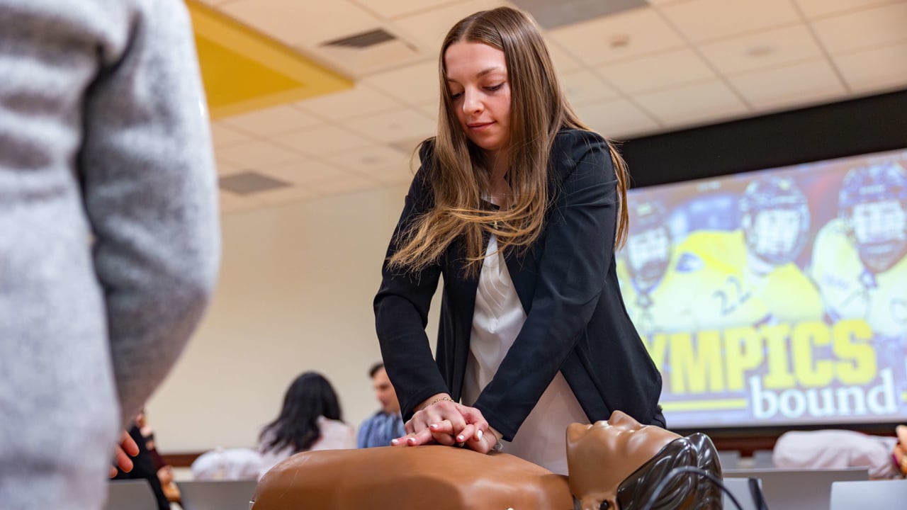 Student practices CPR on a dummy.