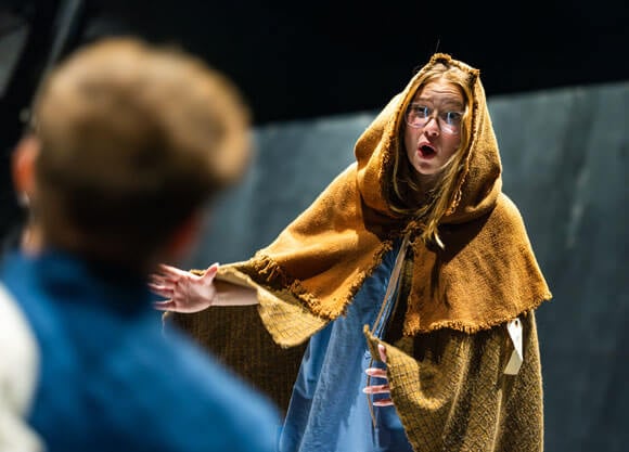 Student in a yellow cloak with a shocked expression on her face