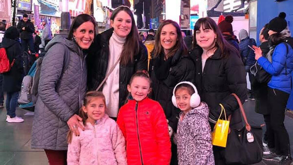 Quinnipiac alumni Meghan Witheril, Katie (Koproski) Mattice, Deena (DeLucia) Scigliano, and Christina Fink pose for a picture with their kids in New York City