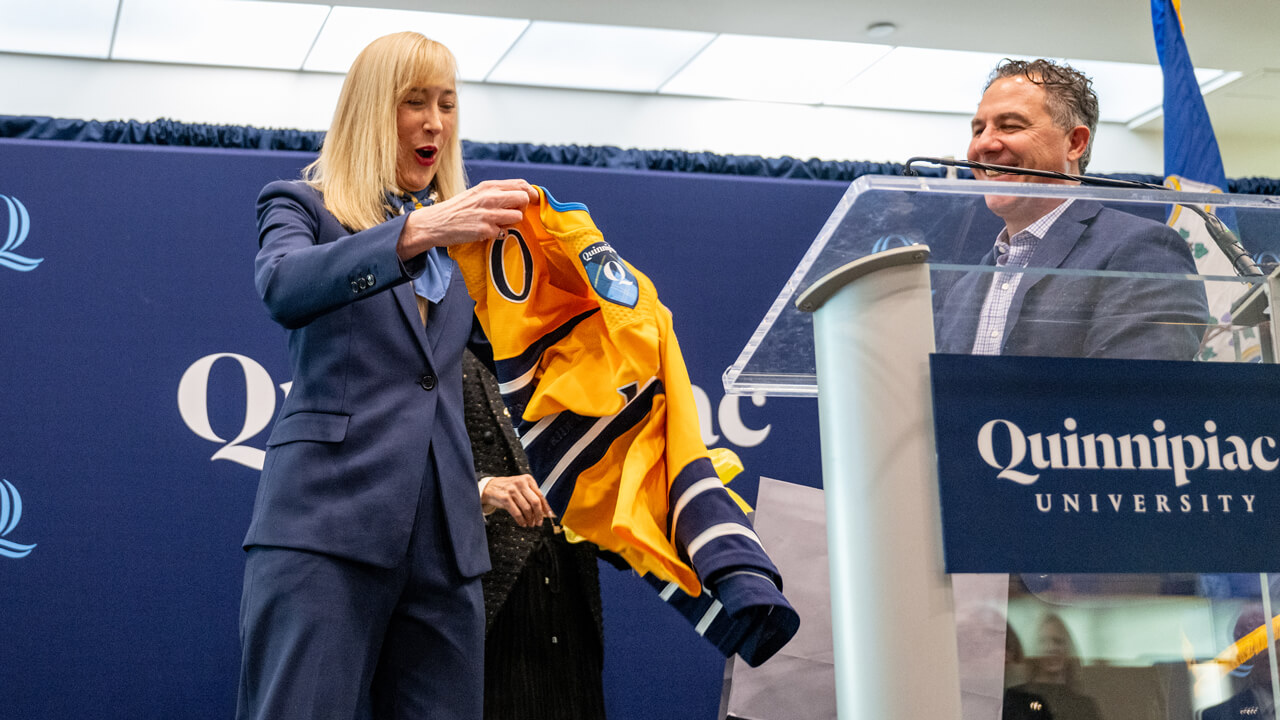 Incoming President Hardin holds a hockey jersey