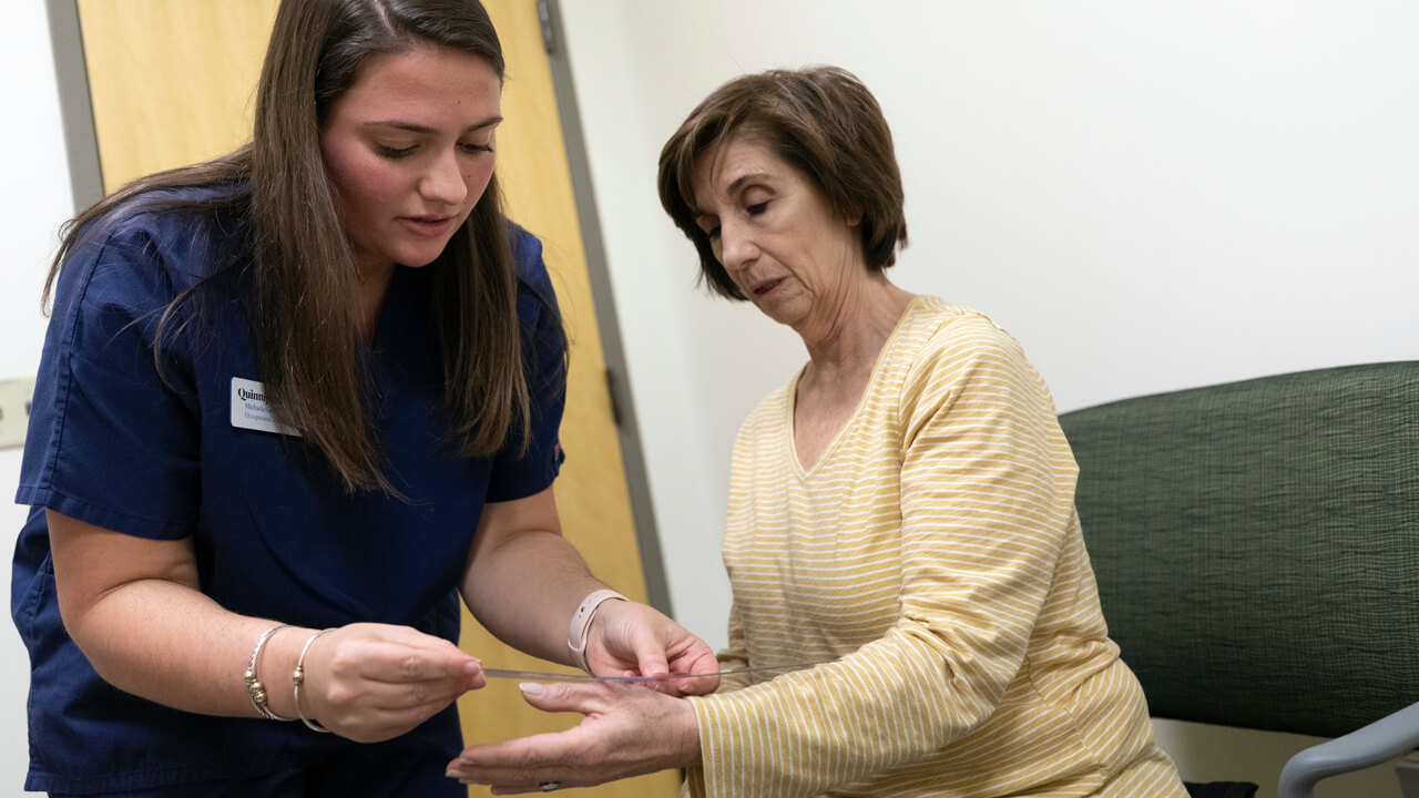 An occupational therapy student evaluates a patient in the simulation suite