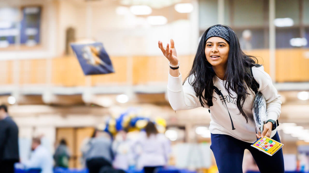 A student throws a bean bag.