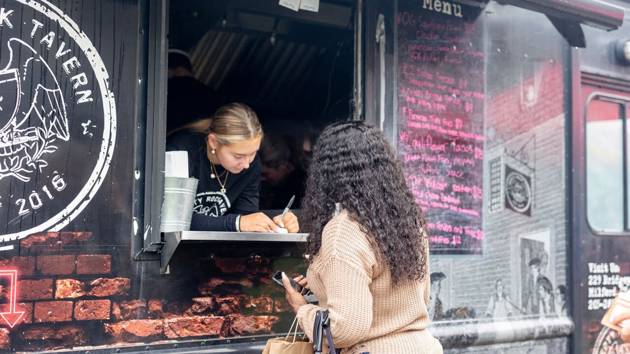 A person orders from a food truck.