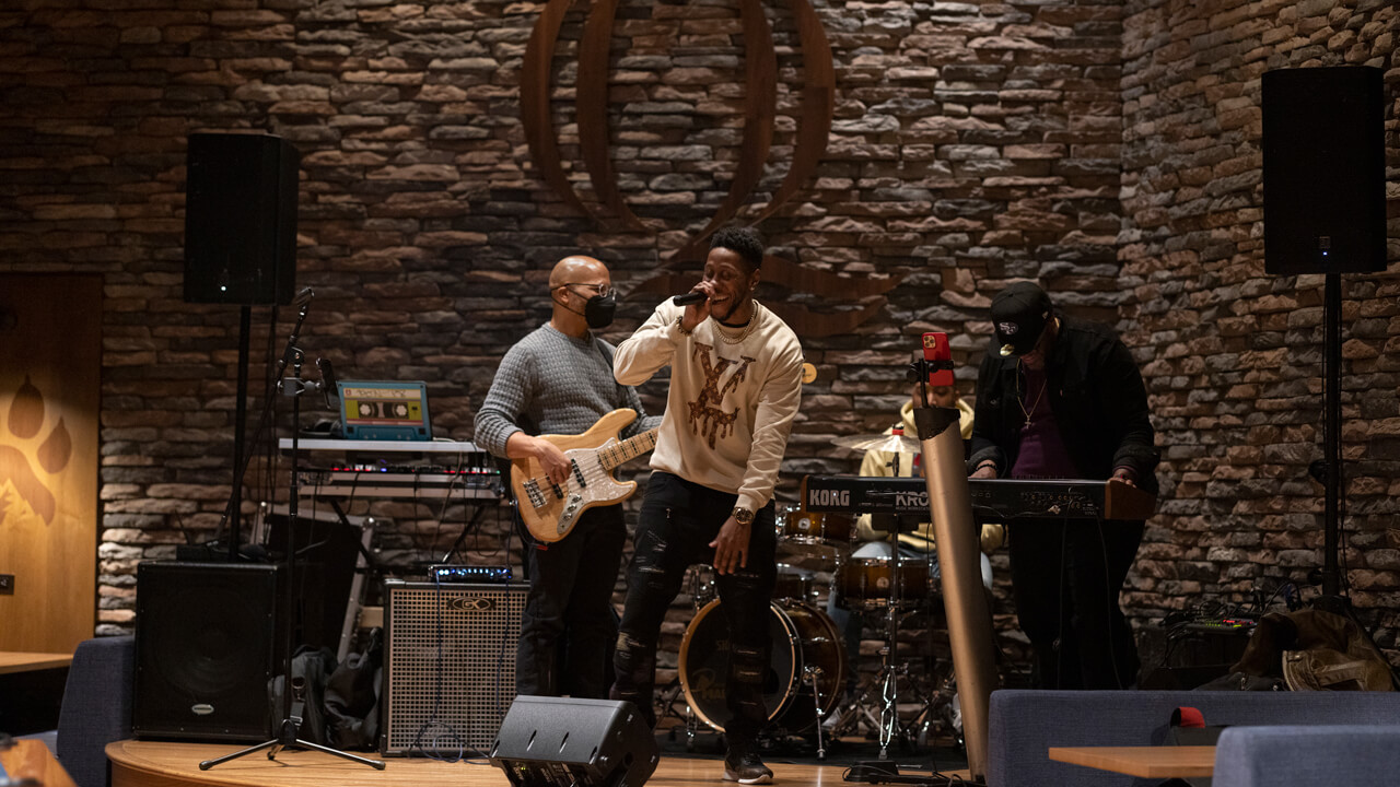 A singer and three musicians perform on the On the Rocks stage