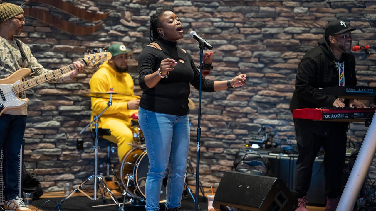 A singer, guitarist, keyboardist and drummer perform on stage at On the Rocks