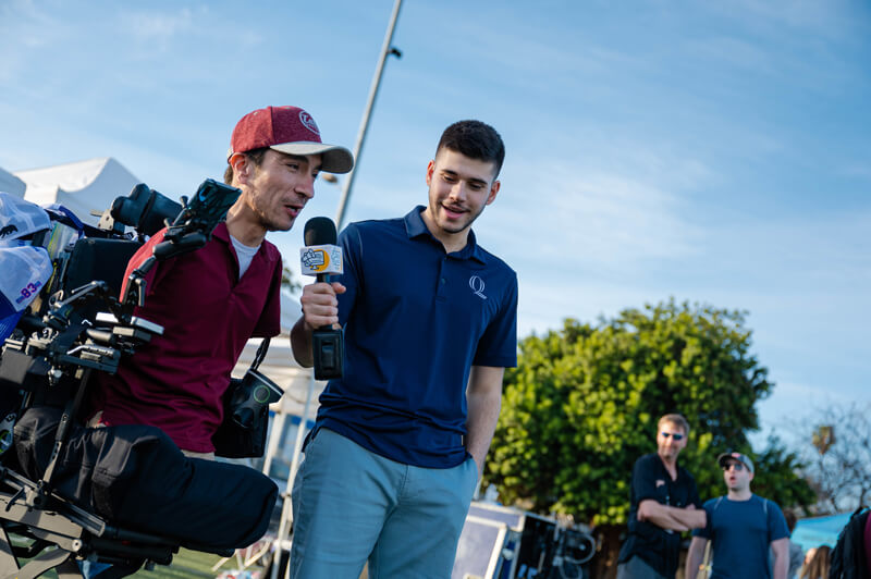 Santino Maione interviews Rob Mendez outside in front of a camera