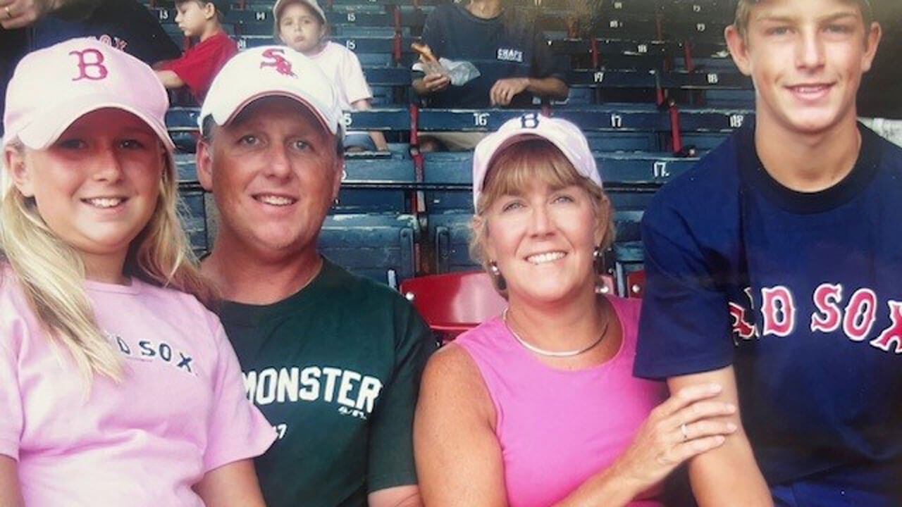 Tina and Tim Saler smiling with their two young children on some bleachers