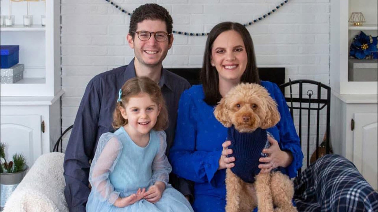 emily and michael sarin pose with their daughter and dog