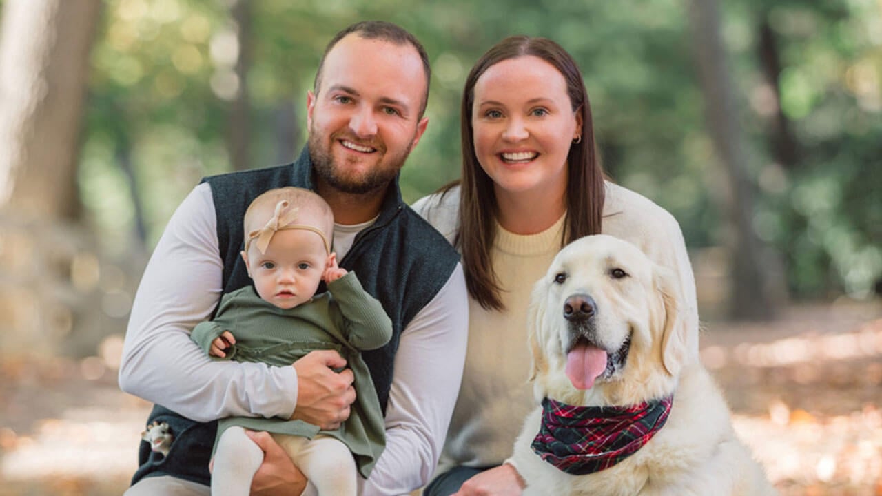 kelly meenan and brendan taylor pose together with their daughter and dog