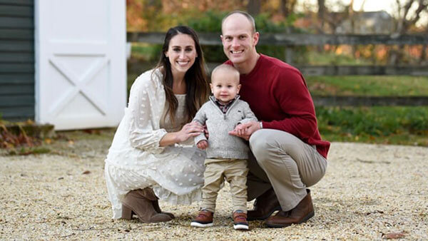 Erica and Keith Yatauro stand outside with their young son.