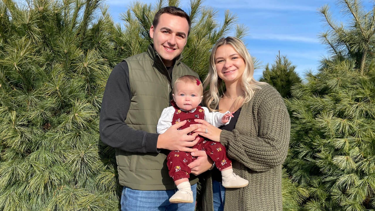 Britni and Branden Hollinghurst smile with their baby.