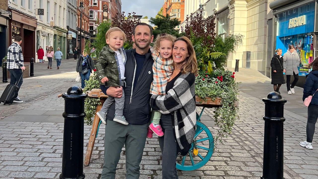 Ali and Zach Boroson holding their children in current day.