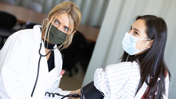 Nursing student checks the blood pressure of her patient.