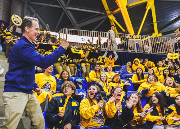 Tom Ellett cheers with dozens of students in the student section during a Quinnipiac hockey game