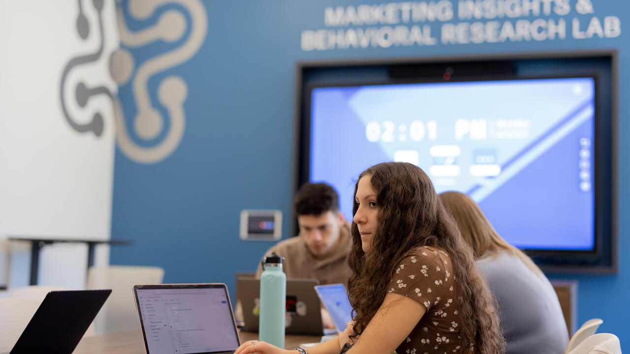 A female student looking off camera in the Marketing Insights and Behavioral Research Lab