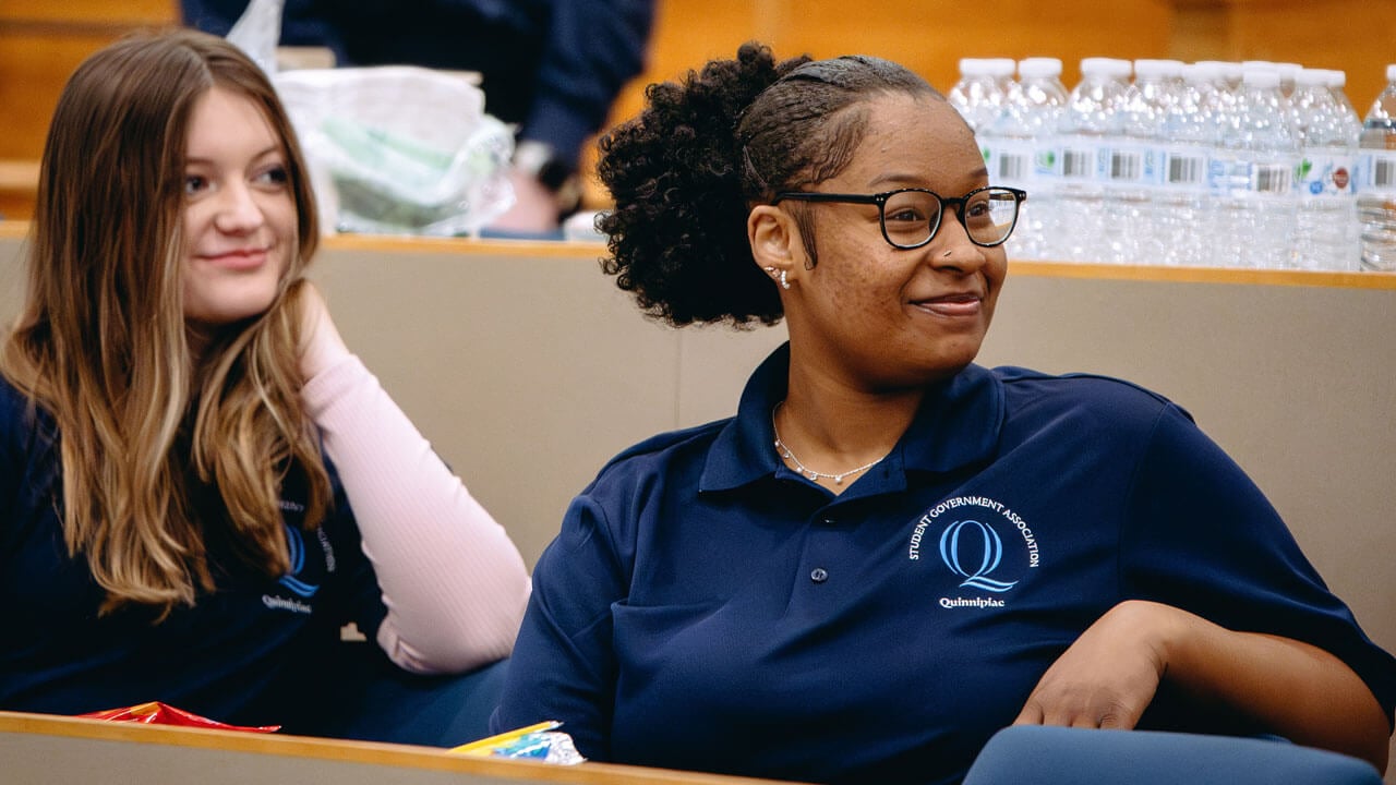 Two students wearing Student Government Association shirts smile.