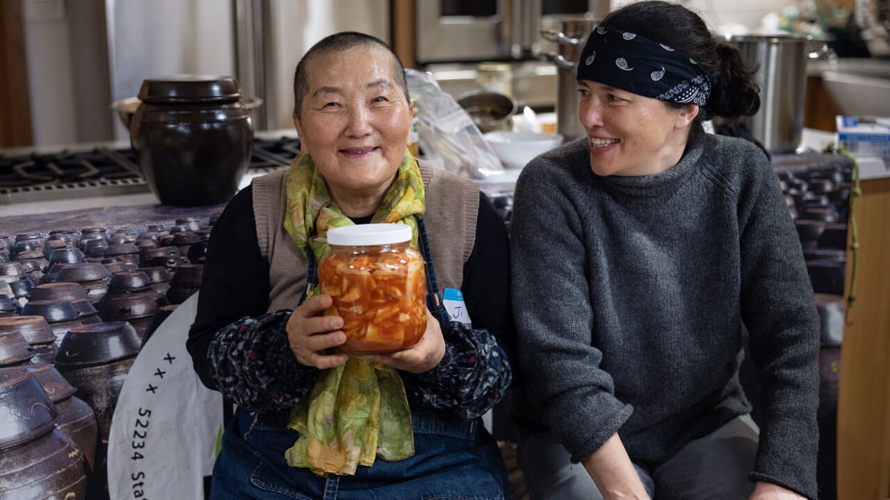 Participants hold up kimchi