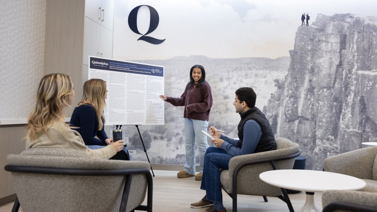 Student presenting a poster to her peers in The Summit