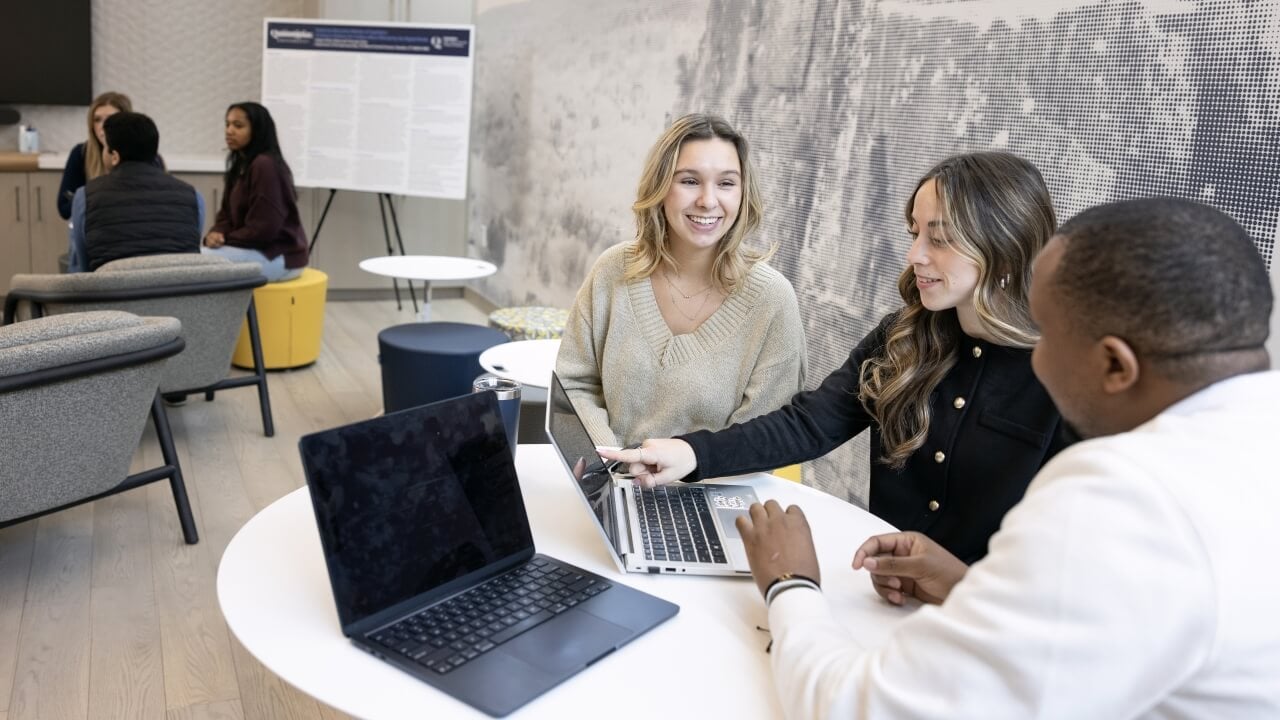 Students sitting a table in The Summit and speaking with one another
