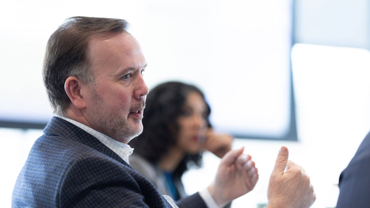Brian T. Kench, University of New Haven, talks to others in the meeting