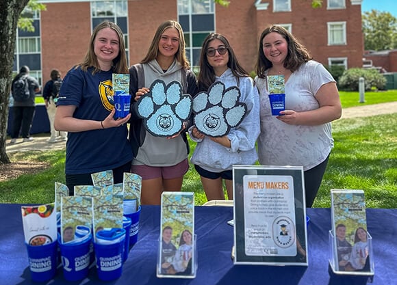 Four student leaders tabling for the Menu Makers