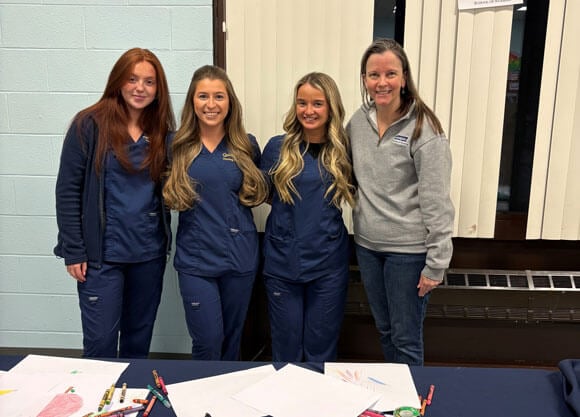 The nurses and professor pose for a photo