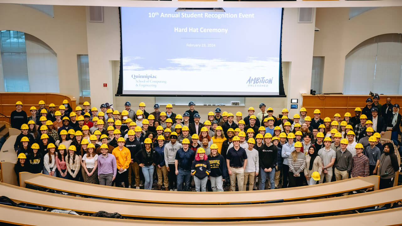 The entire group of students and faculty at the front of the Mount Carmel Auditorium.