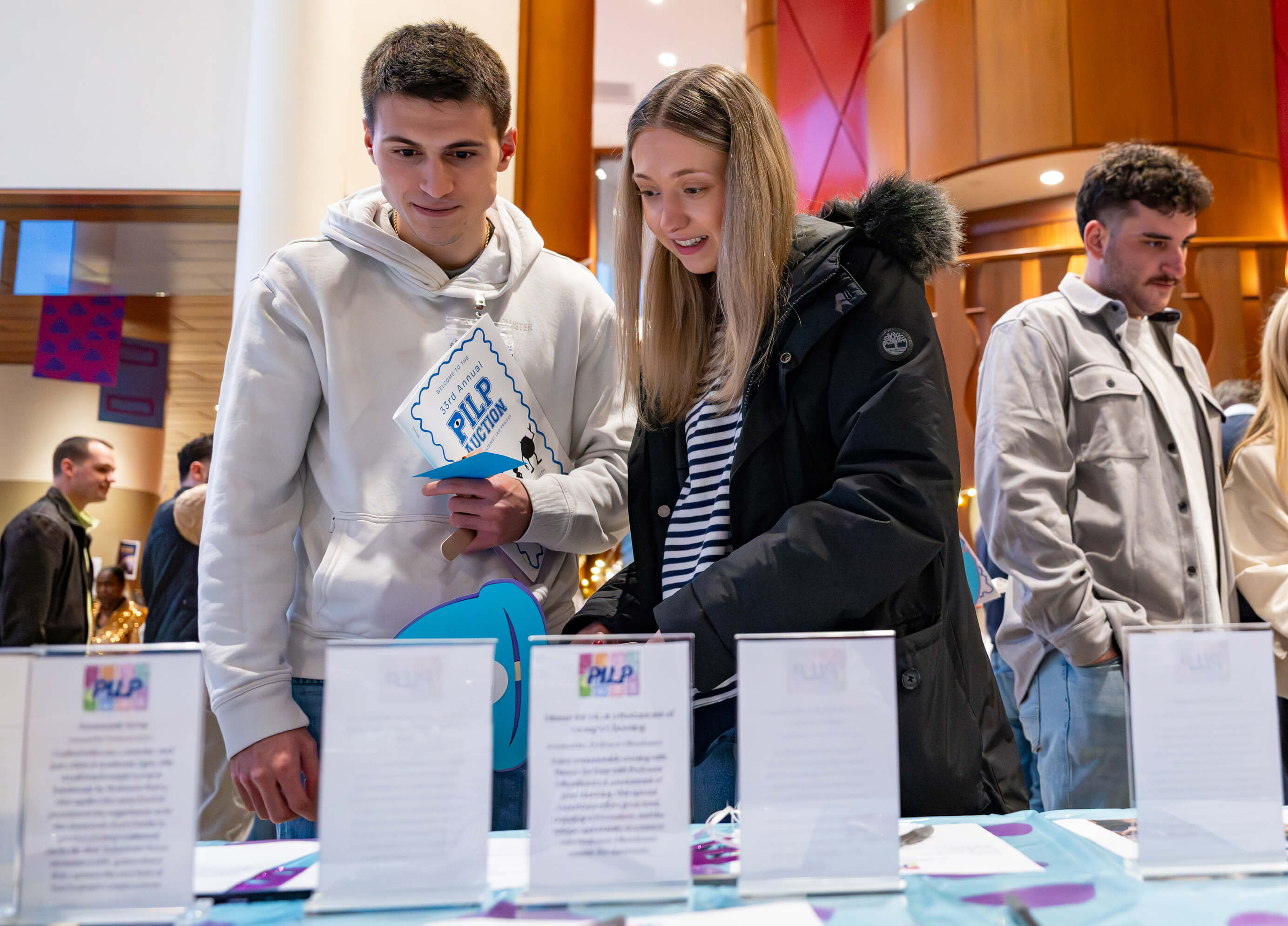 Individuals stand in front of auction tables