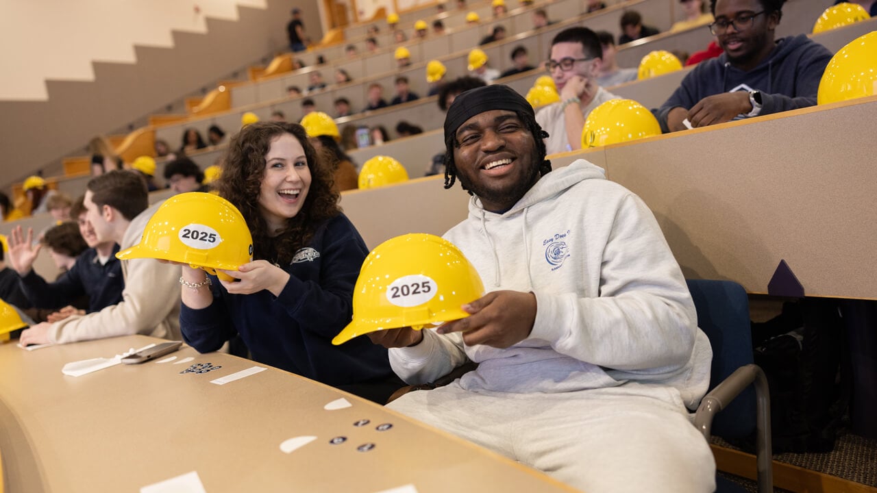 Students pose with hard hats and stickers