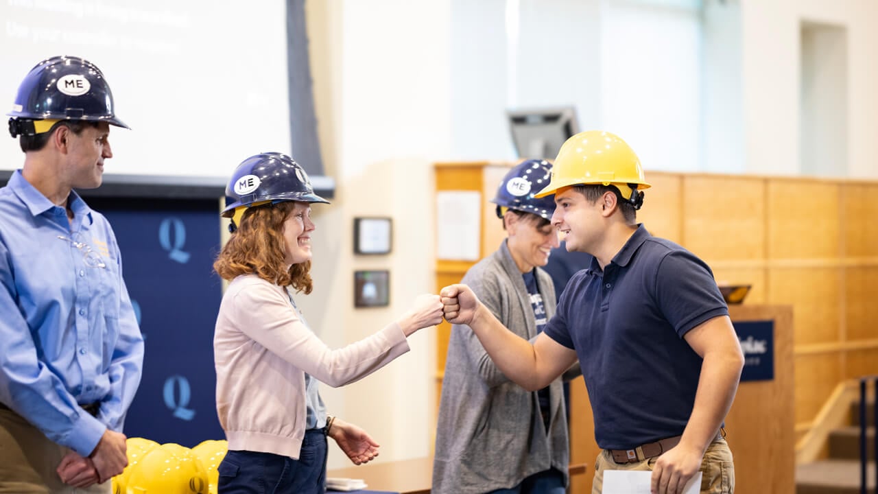 Two people give each other a fist bump