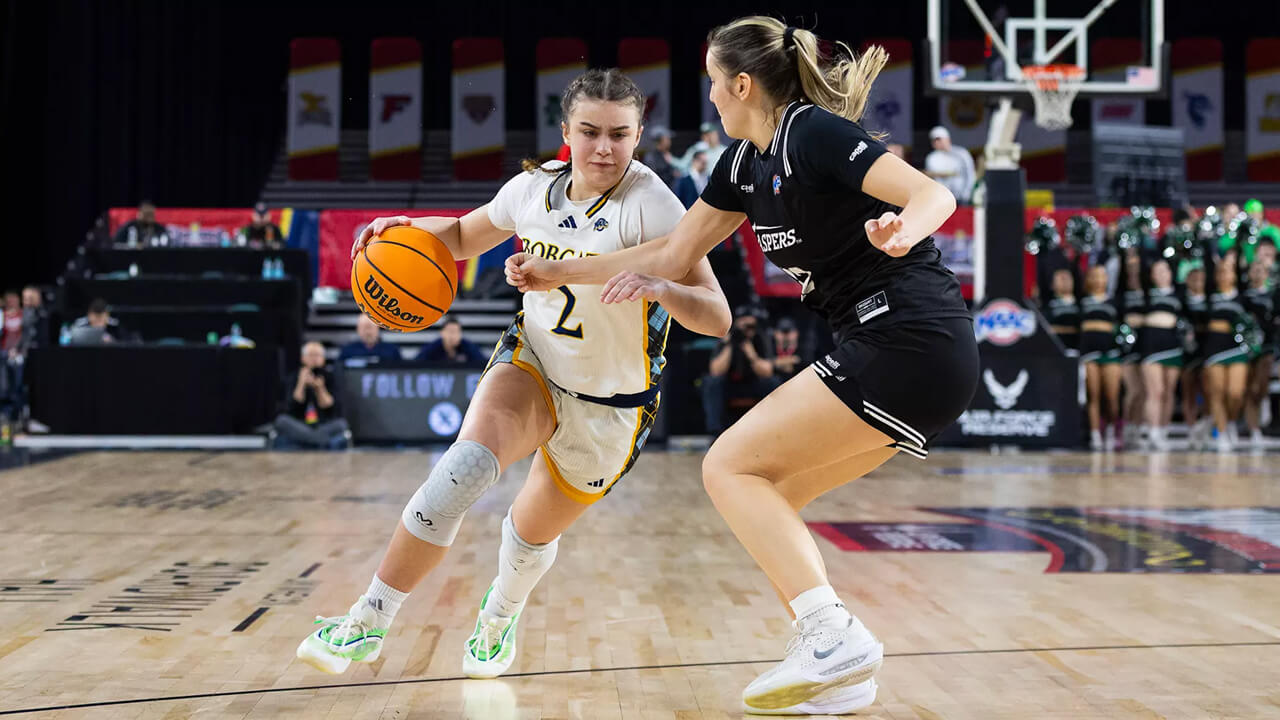 Quinnipiac women's basketball player dribbles around an opponent
