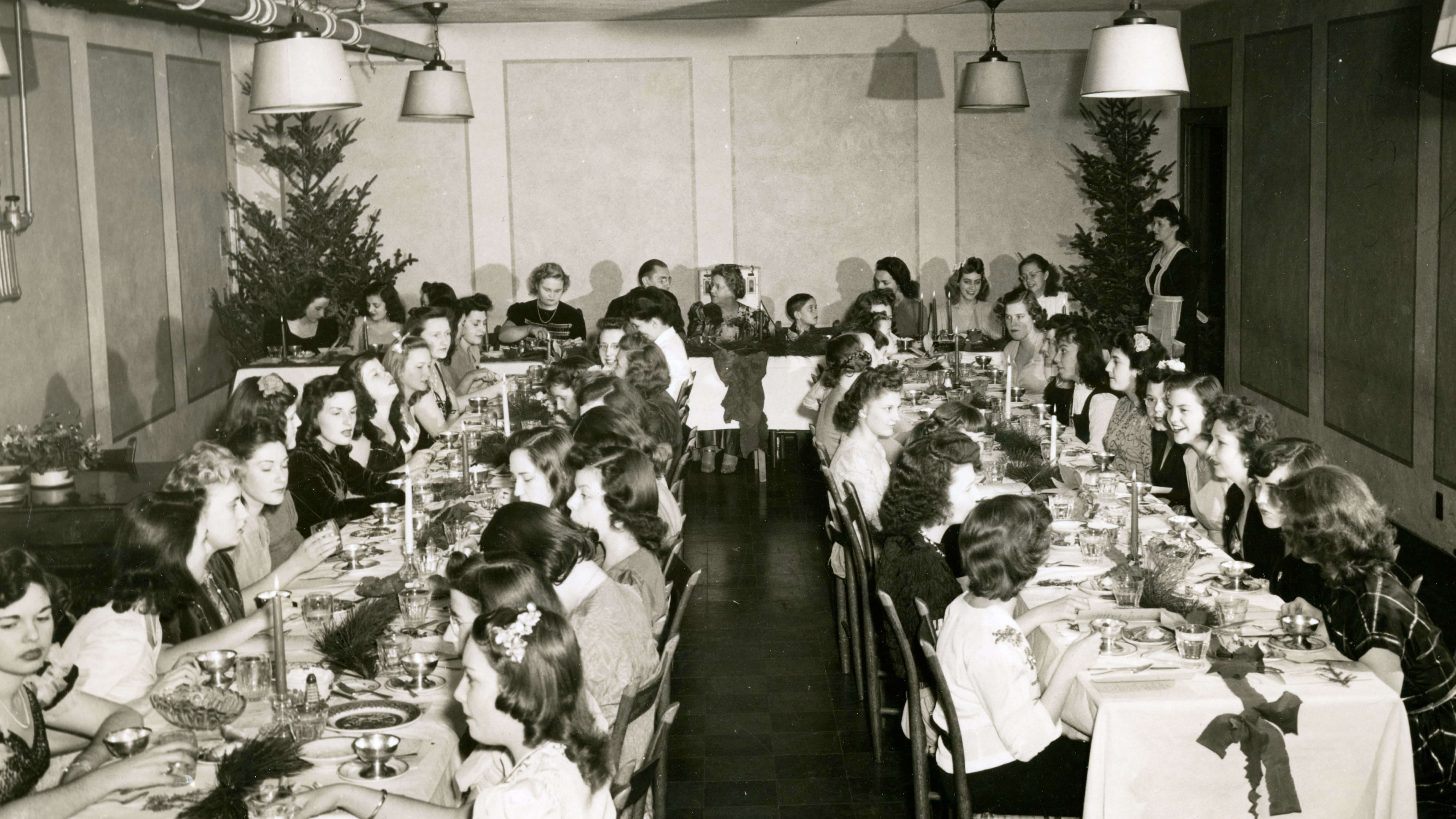 Women sitting at dining room tables chatting over food