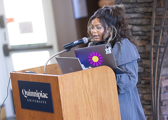 A professor speaks at a podium at the Women's Teach-In.