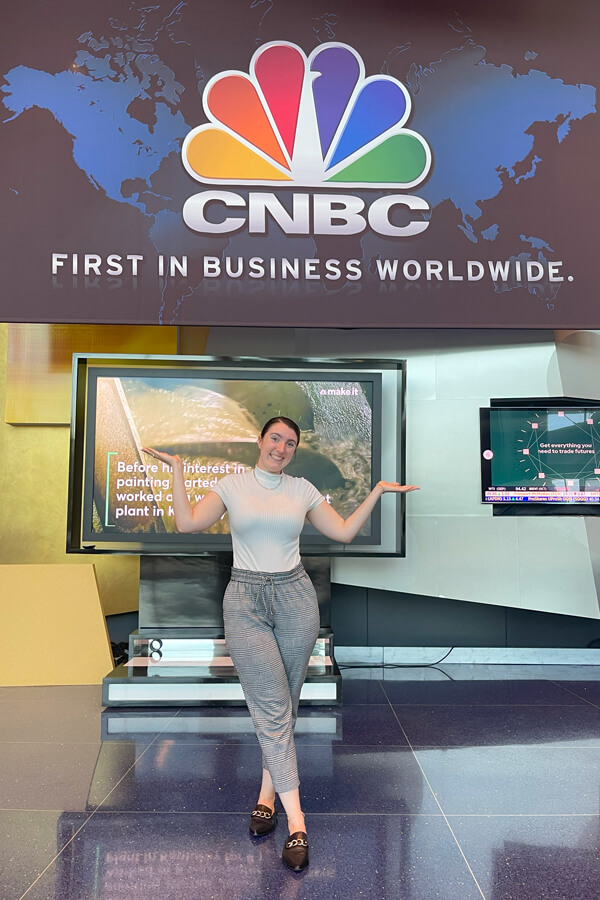 Student intern posing in front of CNBC sign