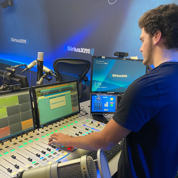 Student intern using a sound board at Sirius XM