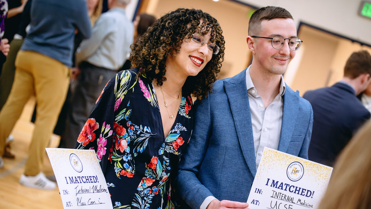 Quinnipiac students smiling holding up their Match Day signs