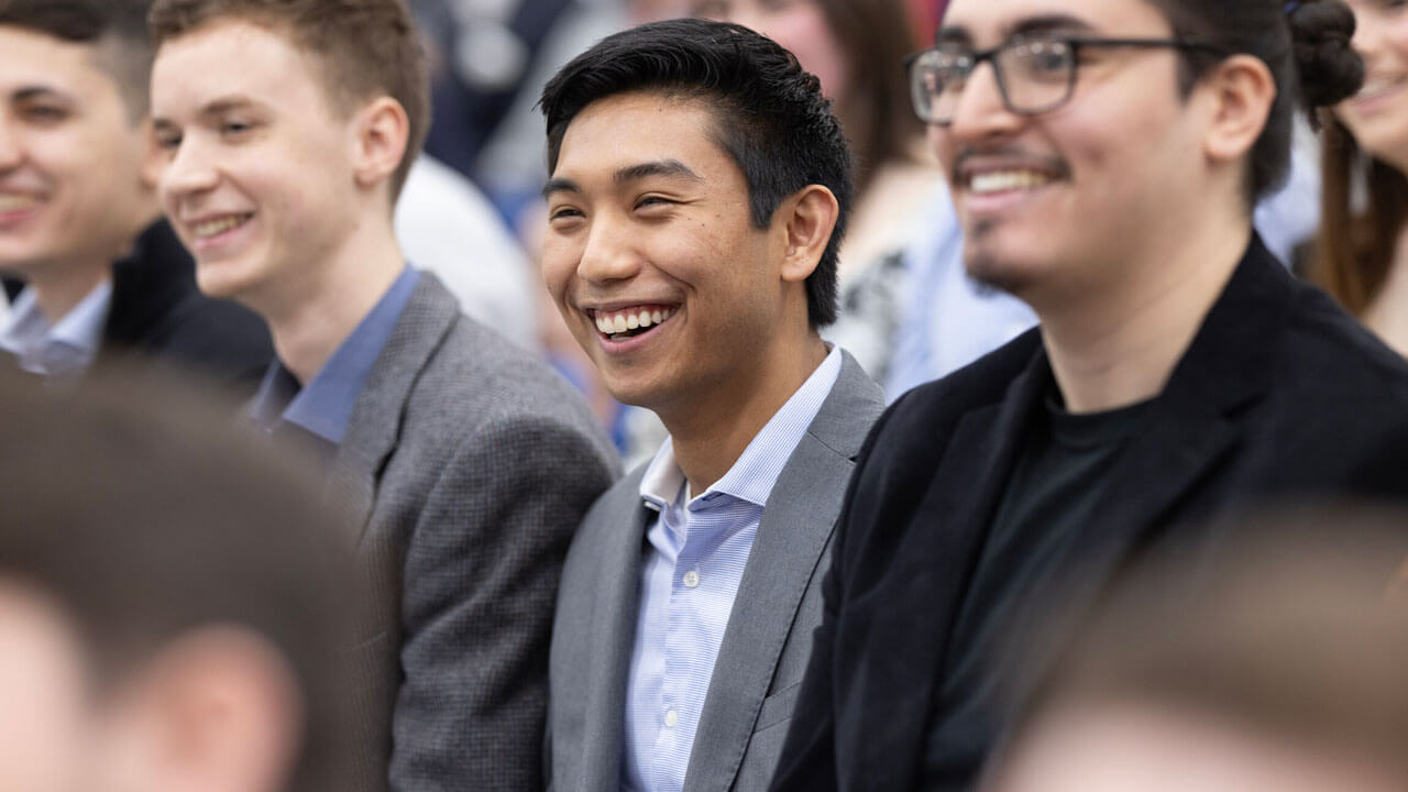 Quinnipiac Class of 2024 med students smile and laugh in the audience