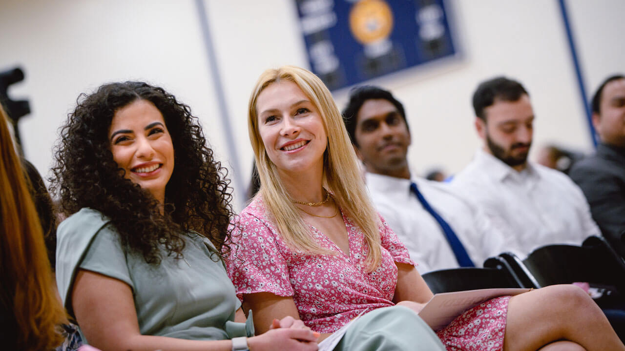 Two graduates smiling during ceremony