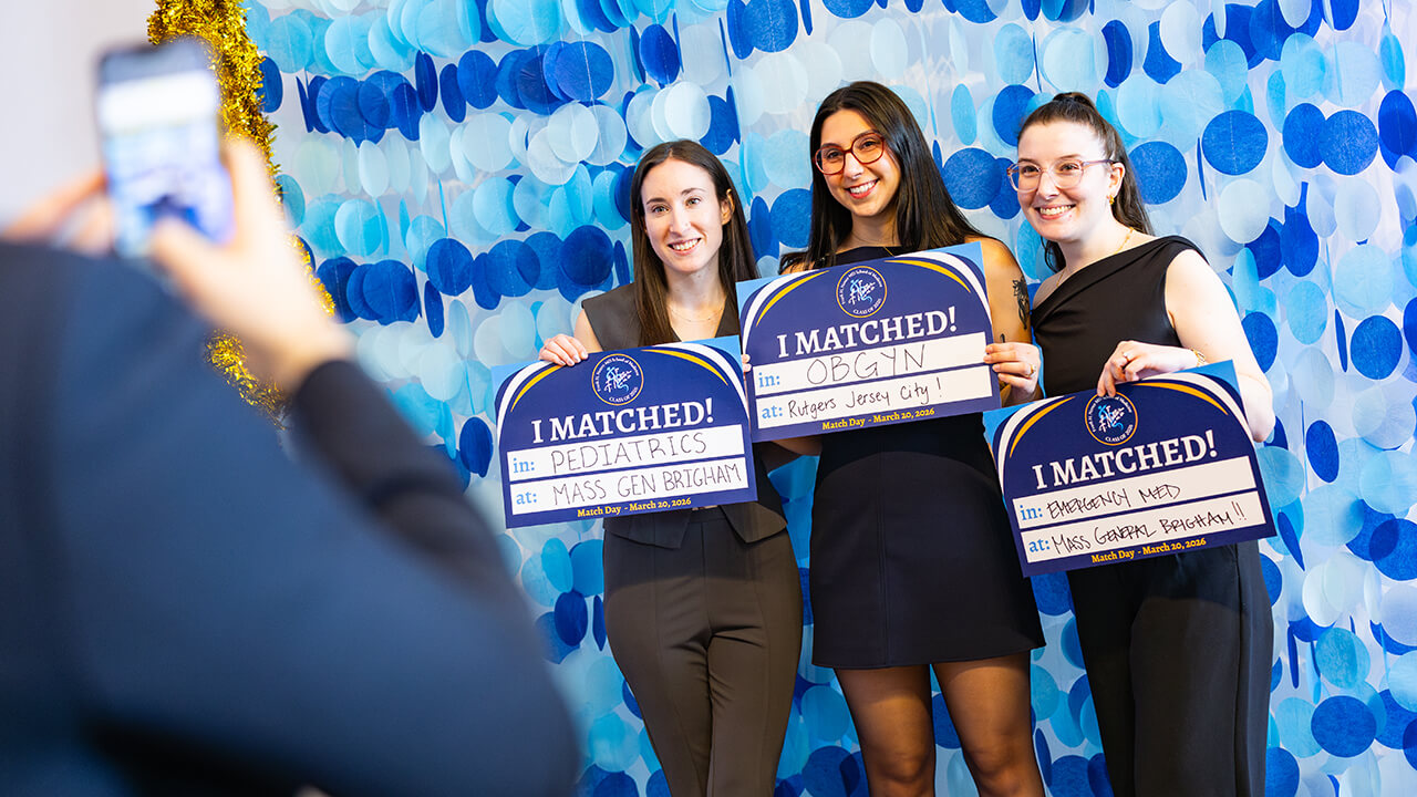 Three students posing with their Match Day signs