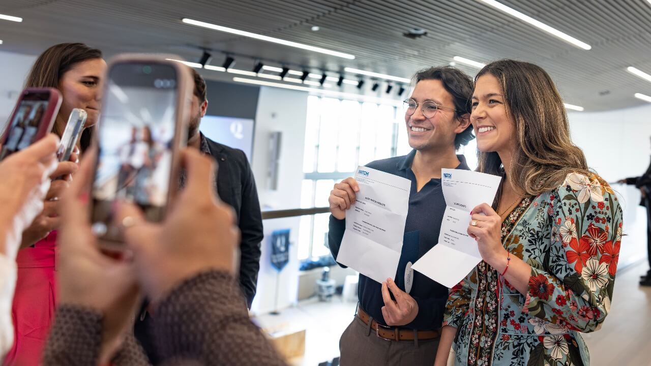 Two students posing with their letters on match day