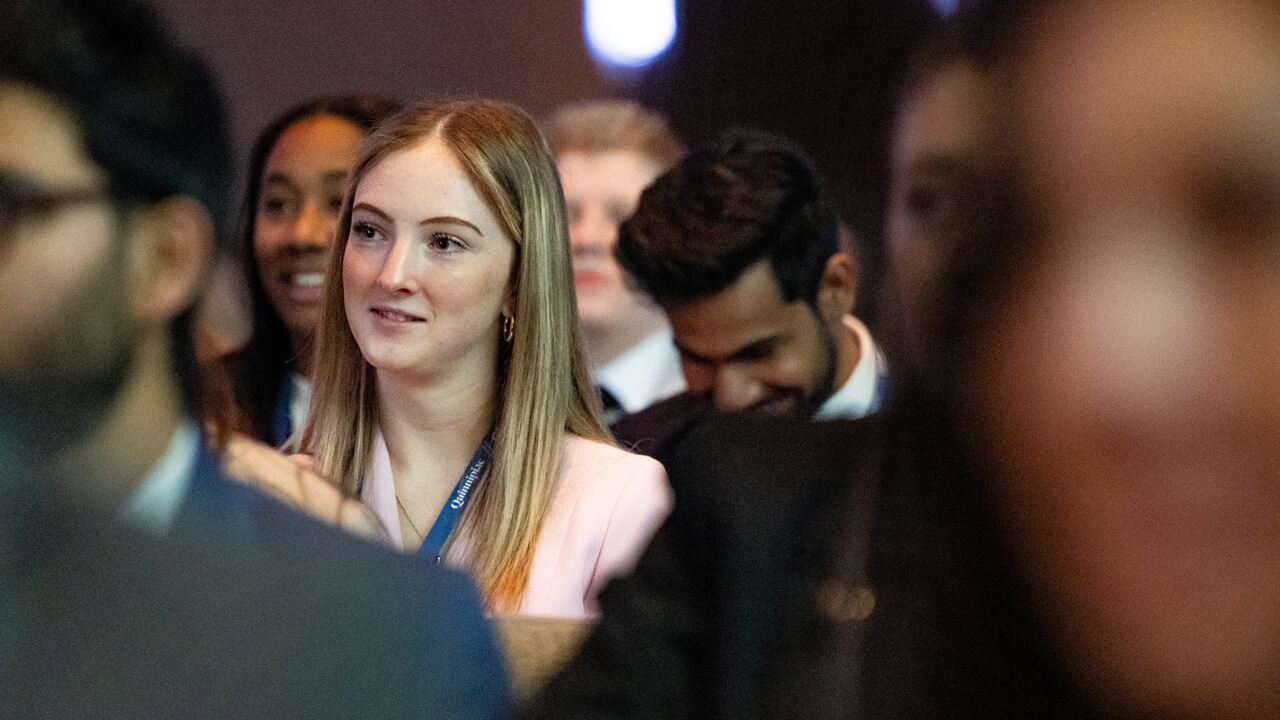 Audience member smiles and enjoys GAME forum presentation