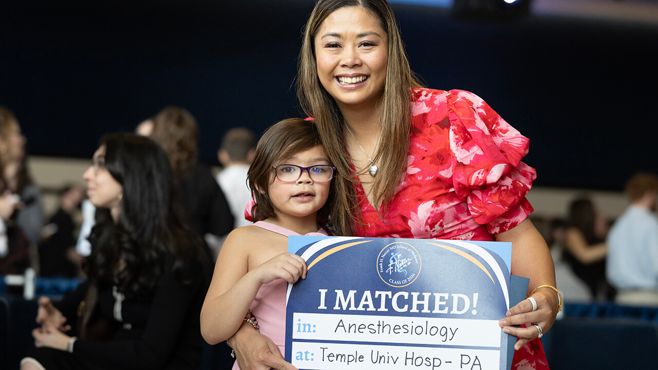Student and young child with Match Day signs